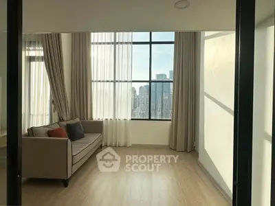 Spacious living room with large windows offering stunning city views and elegant decor.
