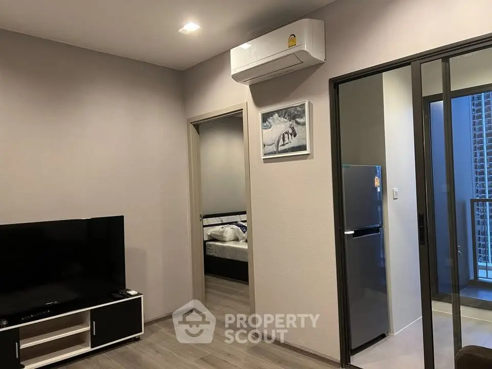 Modern apartment interior with living room, bedroom, and balcony access, featuring sleek design and air conditioning.