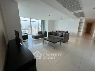 Spacious modern living room with panoramic city view and sleek furniture.