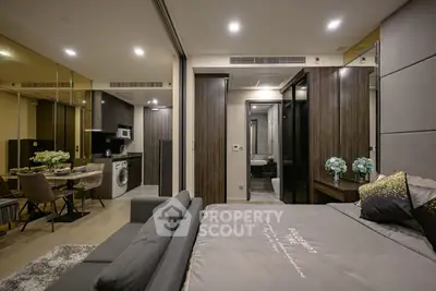 Modern studio apartment with sleek kitchen and cozy living area, featuring elegant decor and ample lighting.