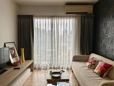 Modern living room with city view, featuring stylish decor and natural light through large windows.