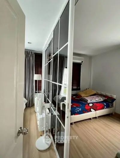 Cozy bedroom with mirrored closet and colorful bedding