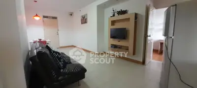 Spacious living room with modern decor and wall-mounted TV in a cozy apartment.