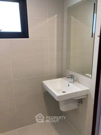 Modern bathroom with sleek sink and large mirror in a minimalist design.