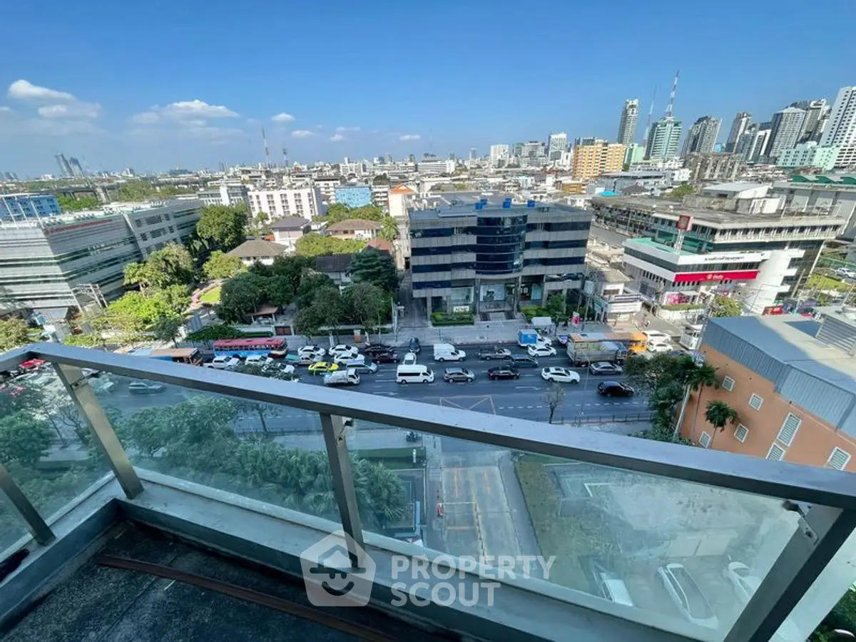 Stunning city view from a high-rise balcony overlooking bustling streets and skyline.