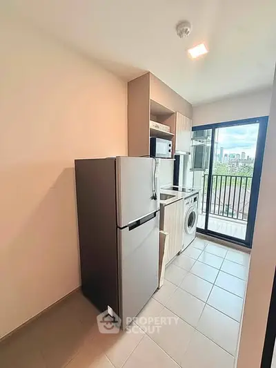Modern kitchen with appliances and balcony view in urban apartment