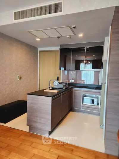 Modern kitchen with sleek cabinetry and built-in microwave in stylish apartment