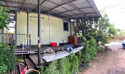Charming rustic exterior with covered porch and lush greenery, perfect for serene living.