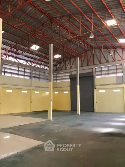 Spacious industrial warehouse with high ceilings and ample natural light.