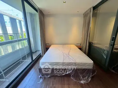 Modern bedroom with large windows and balcony access in a stylish apartment