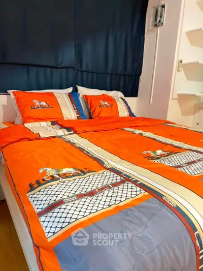 Cozy bedroom with vibrant orange bedding and stylish decor