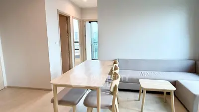 Modern living room with light wood furniture and balcony view in a stylish apartment.