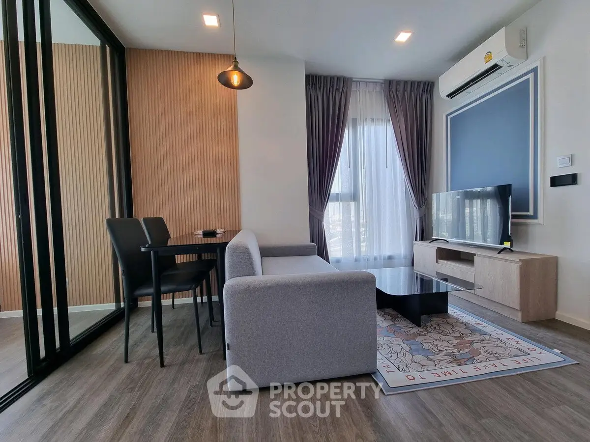 Modern living room with stylish decor, featuring a cozy sofa, TV, and dining area in a chic apartment.