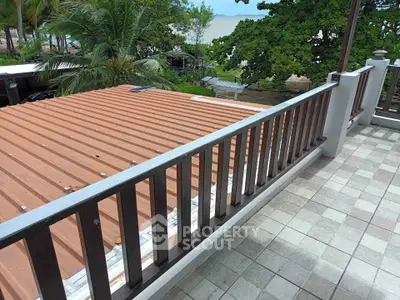 Spacious balcony with ocean view and lush greenery, perfect for relaxation.