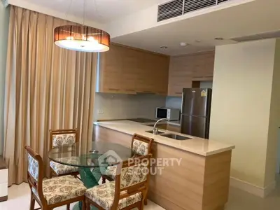 Modern kitchen with open layout and stylish dining area in a cozy apartment.