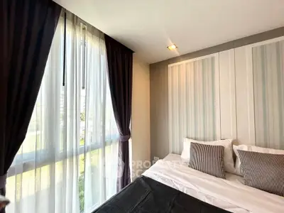 Modern bedroom with large windows and elegant curtains in a stylish apartment.