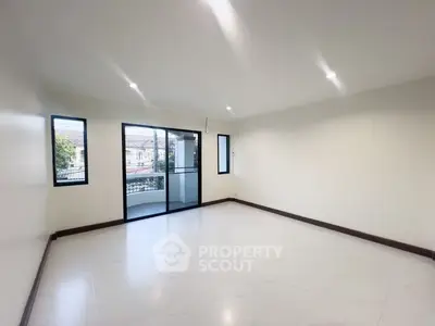Spacious empty living room with large windows and balcony access