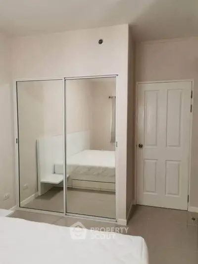 Modern bedroom with mirrored closet doors and minimalist design