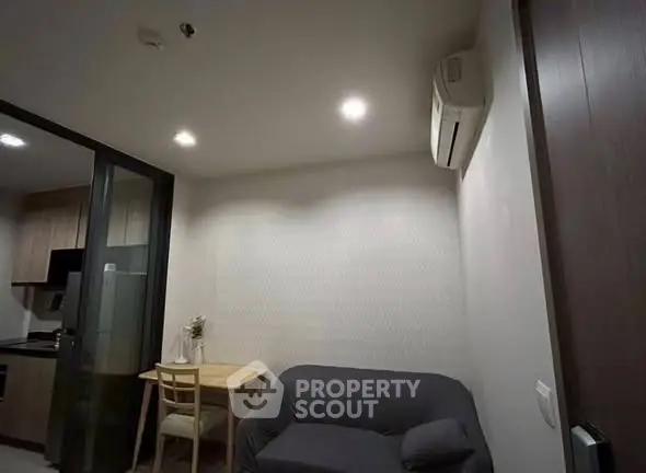 Cozy apartment interior with modern kitchen and comfortable living area, featuring air conditioning and stylish decor.