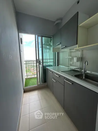 Modern kitchen with sleek cabinetry and balcony view, perfect for urban living.