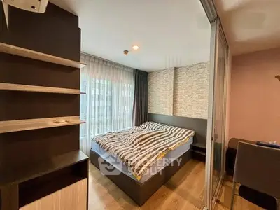 Modern bedroom with large window and stylish decor in a cozy apartment.