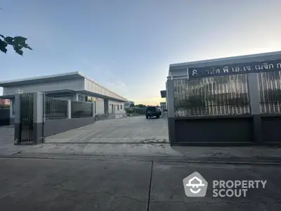 Industrial warehouse exterior with gated entrance and spacious driveway