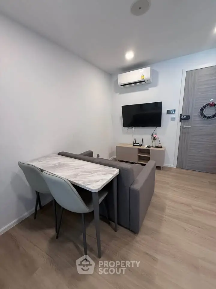 Modern living room with sleek furniture and wall-mounted TV, perfect for cozy urban living.