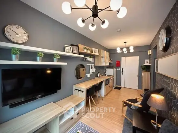 Modern living room with stylish decor and open kitchen layout, featuring sleek furniture and contemporary lighting.