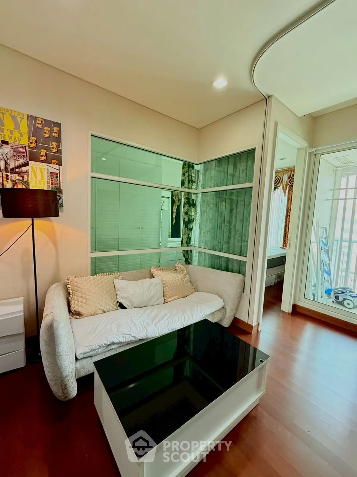Modern living room with stylish decor and glass partition, featuring cozy sofa and sleek coffee table.