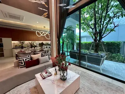 Luxurious living room with modern decor and garden view, featuring open layout and elegant furnishings.