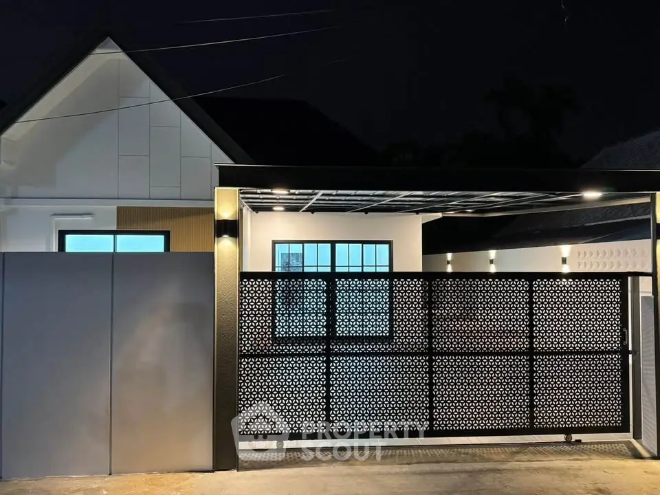 Modern house exterior with stylish gate and ambient lighting at night