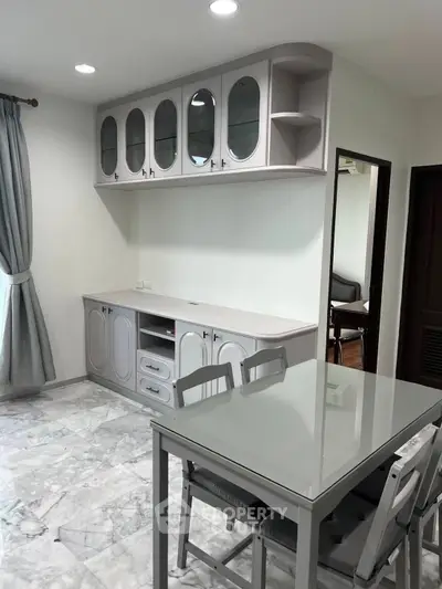 Modern dining area with elegant cabinetry and marble flooring in a stylish apartment.