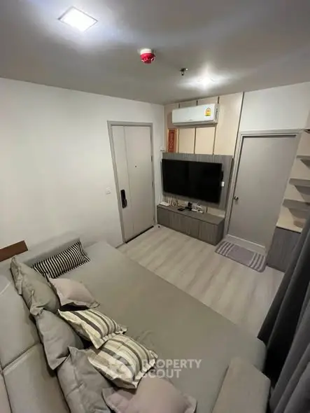 Modern living room with cozy sofa and wall-mounted TV in stylish apartment.