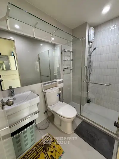 Modern bathroom with glass shower, sleek fixtures, and ample lighting