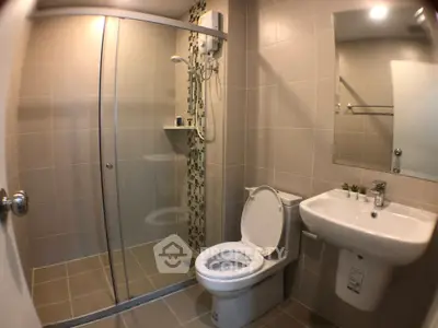 Modern bathroom with glass shower and sleek fixtures in contemporary home.