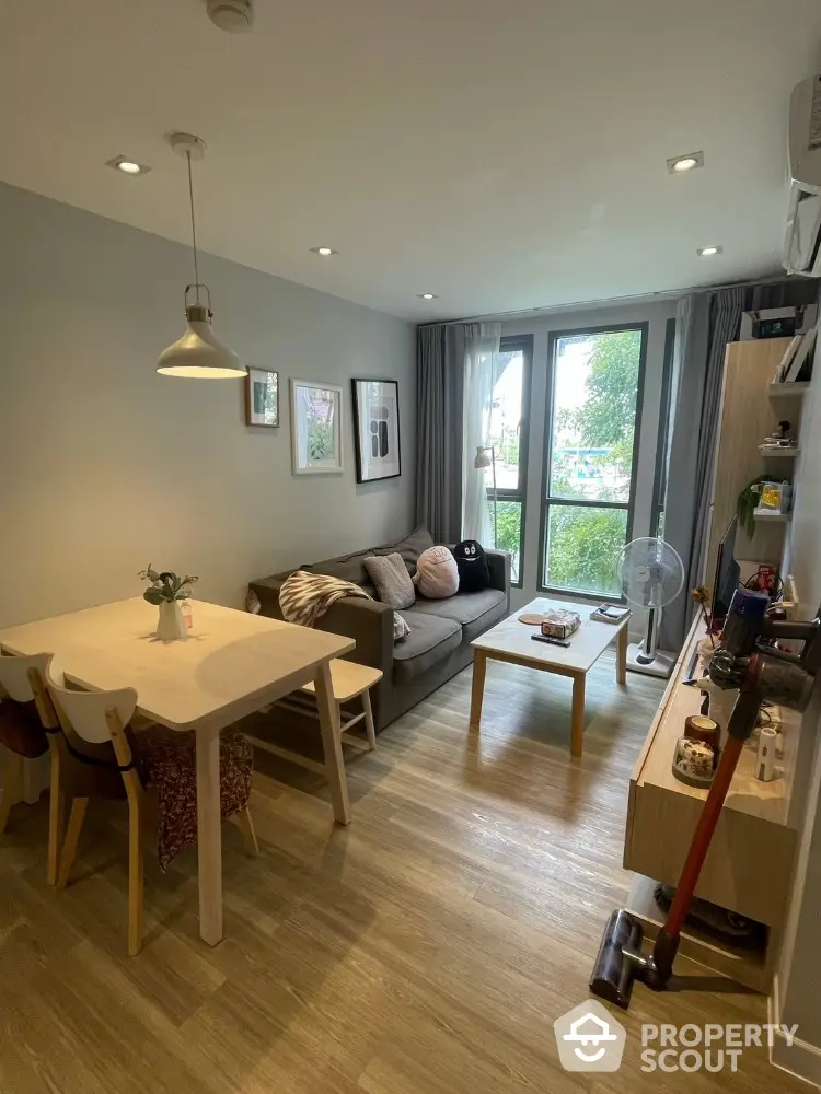 Modern living room with cozy seating and dining area, large window view, and stylish decor.