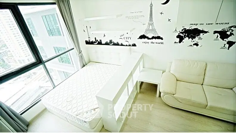 Bright bedroom with city view, stylish wall art, and cozy furniture.