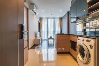Modern apartment interior with open kitchen and living area, featuring sleek appliances and stylish decor.