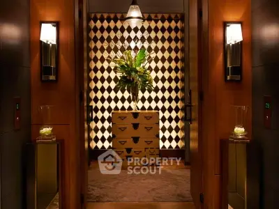 Luxurious hallway with elegant lighting and stylish decor, featuring a chic patterned wall and decorative plants.