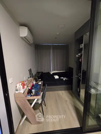 Modern bedroom with sleek design and workspace, featuring a cozy bed and stylish decor.