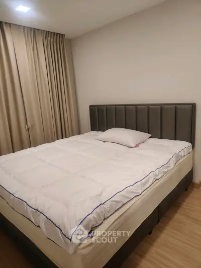 Cozy bedroom with modern bed and elegant curtains, perfect for restful nights.