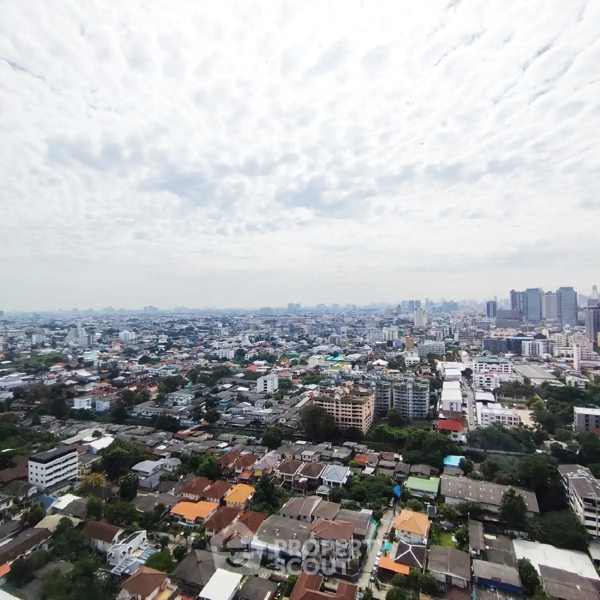 Stunning panoramic cityscape view showcasing urban skyline and residential areas under a cloudy sky.