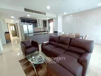 Spacious modern living room with leather sofa and open kitchen layout