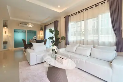 Elegant living room with white sofa and modern decor in a bright, airy space.