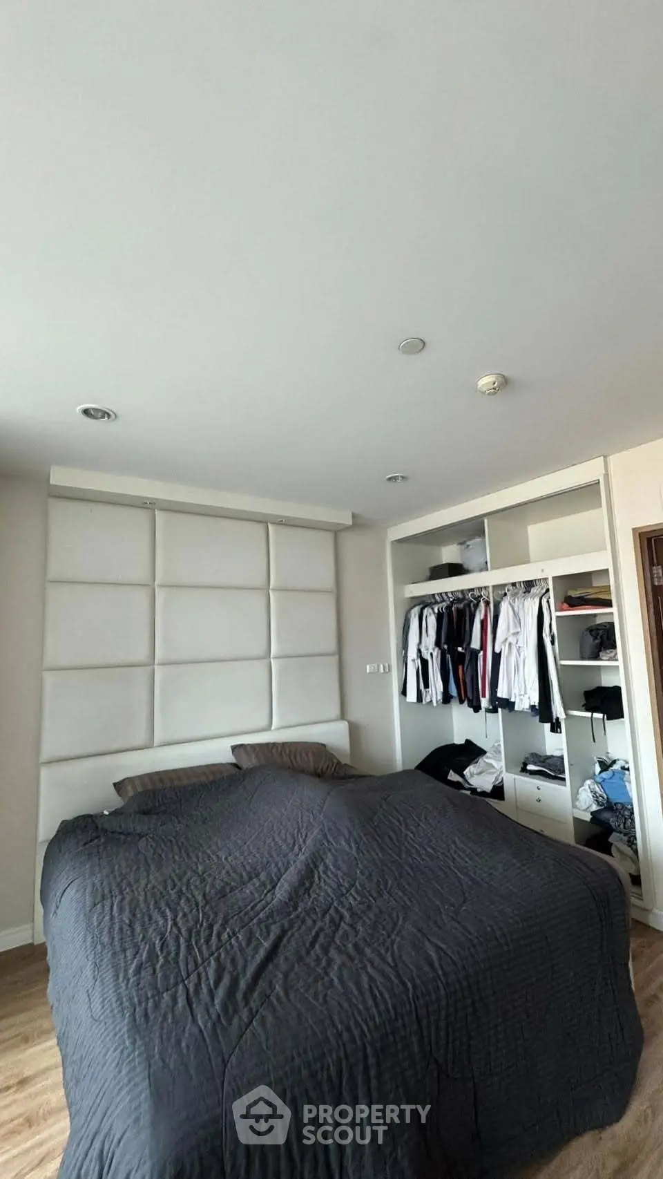 Spacious bedroom with modern built-in wardrobe and cozy bedding in a stylish apartment.