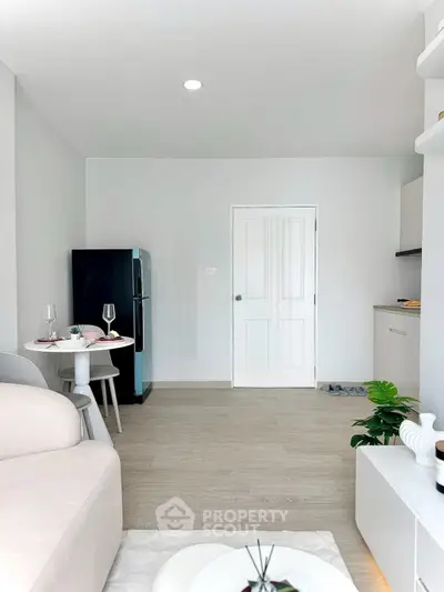 Modern living room with sleek design, featuring a cozy sofa, compact dining area, and stylish kitchen corner.