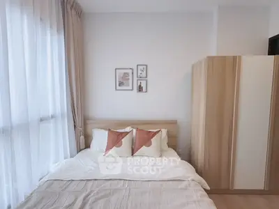 Cozy bedroom with natural light, modern decor, and wooden wardrobe