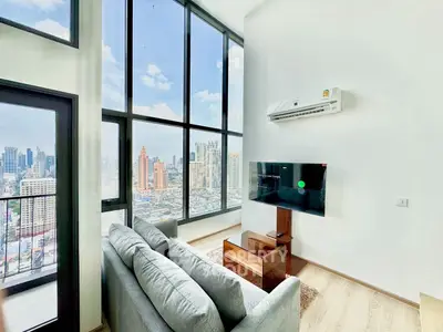 Stunning high-rise living room with floor-to-ceiling windows and city skyline view.