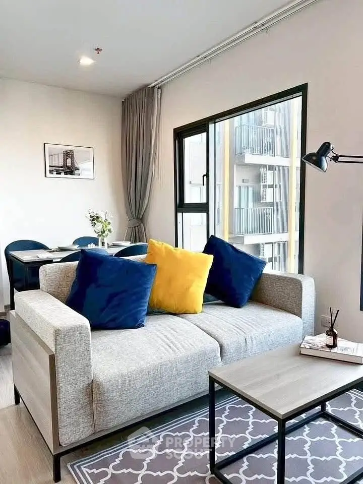 Modern living room with stylish decor and large window in a contemporary apartment.