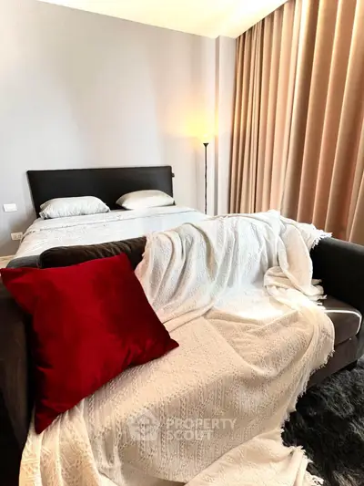 Cozy bedroom with elegant decor, featuring a plush bed, stylish sofa, and ambient lighting for a relaxing atmosphere.